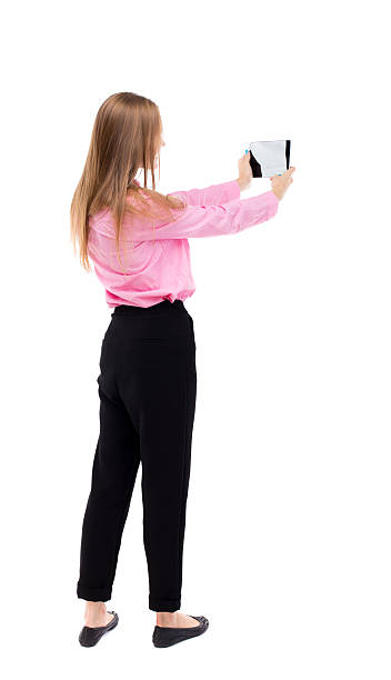 istock back view of standing young beautiful  girl with tablet computer 511985608