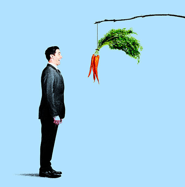 istock Businessman Looking At Carrots Dangling From Stick. 511987292