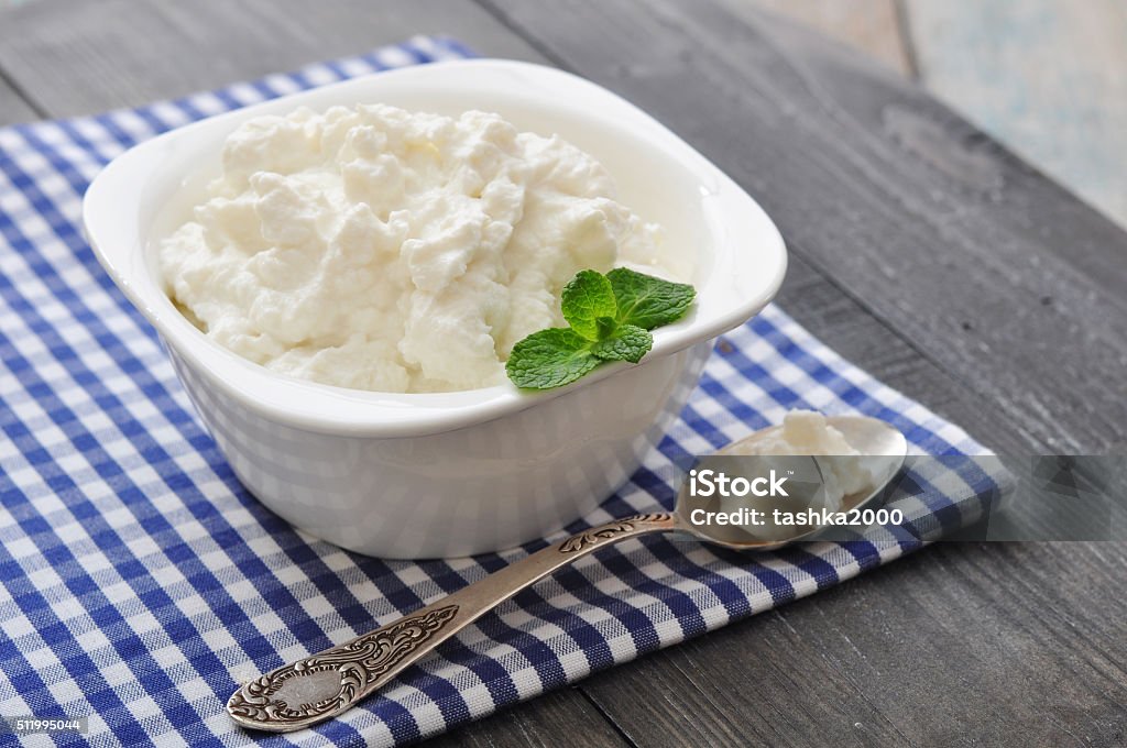 Ricotta cheese Ricotta cheese in bowl with mint on wooden background Ricotta Stock Photo