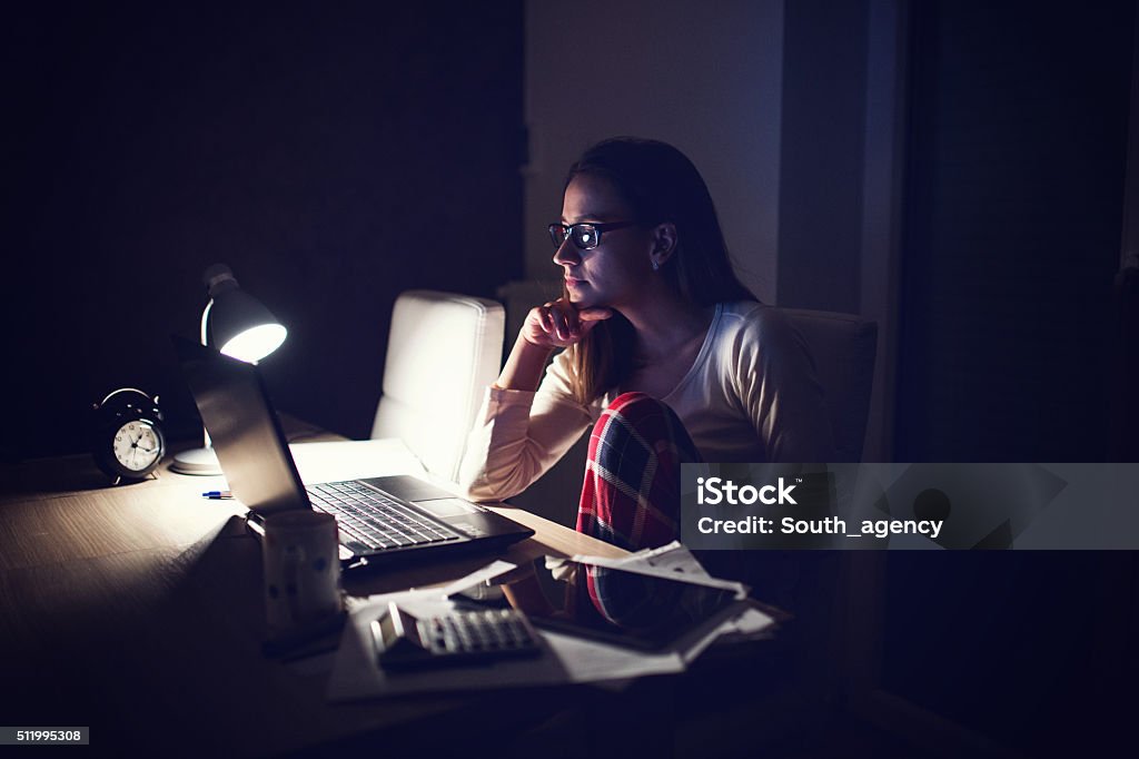 Tired Woman working at home,making a break Scene of a exhausted young business woman working late at night to meet an urgent deadline. Pajamas Stock Photo