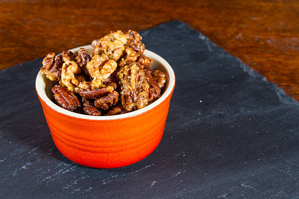 istock Bowl with mixed garlic and rosemary roasted nuts, macro. 511996096