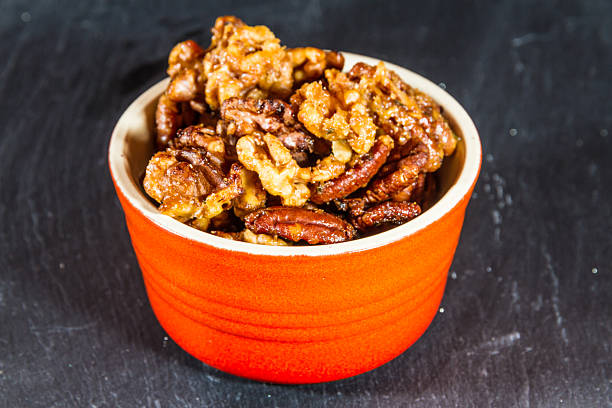 istock Bowl with mixed garlic and rosemary roasted nuts, macro. 511996228
