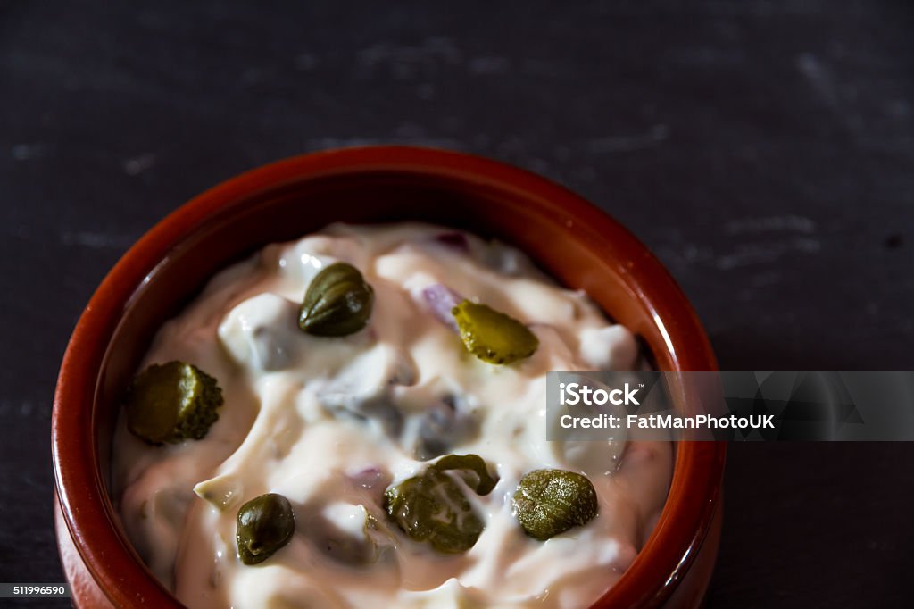 Bowl of home made tartare sauce. Tartare sauce in brown ceramic bowl, dark background. Caper Stock Photo