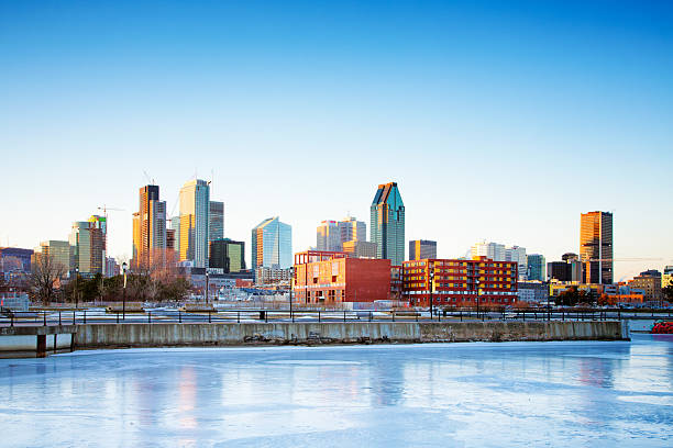 Montreal skyline above frozen canal at sunset during a cold February Winter day.