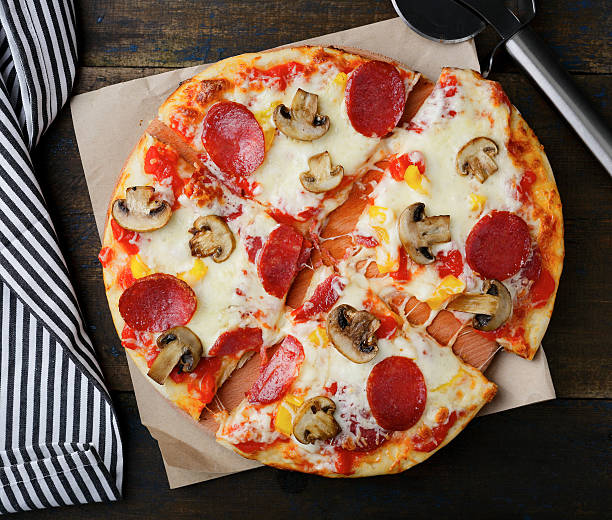 istock Pepperoni Pizza with mushrooms on a wooden table 511997036