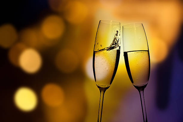 istock Toasting with champagne glasses against holiday lights 511998018