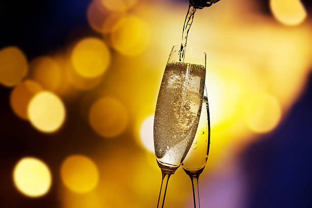 istock Toasting with champagne glasses against holiday lights 511998688
