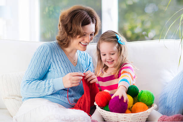 istock Mother and daughter knitting woolen scarf 511998776