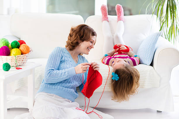 istock Mother and daughter knitting woolen scarf 512000990