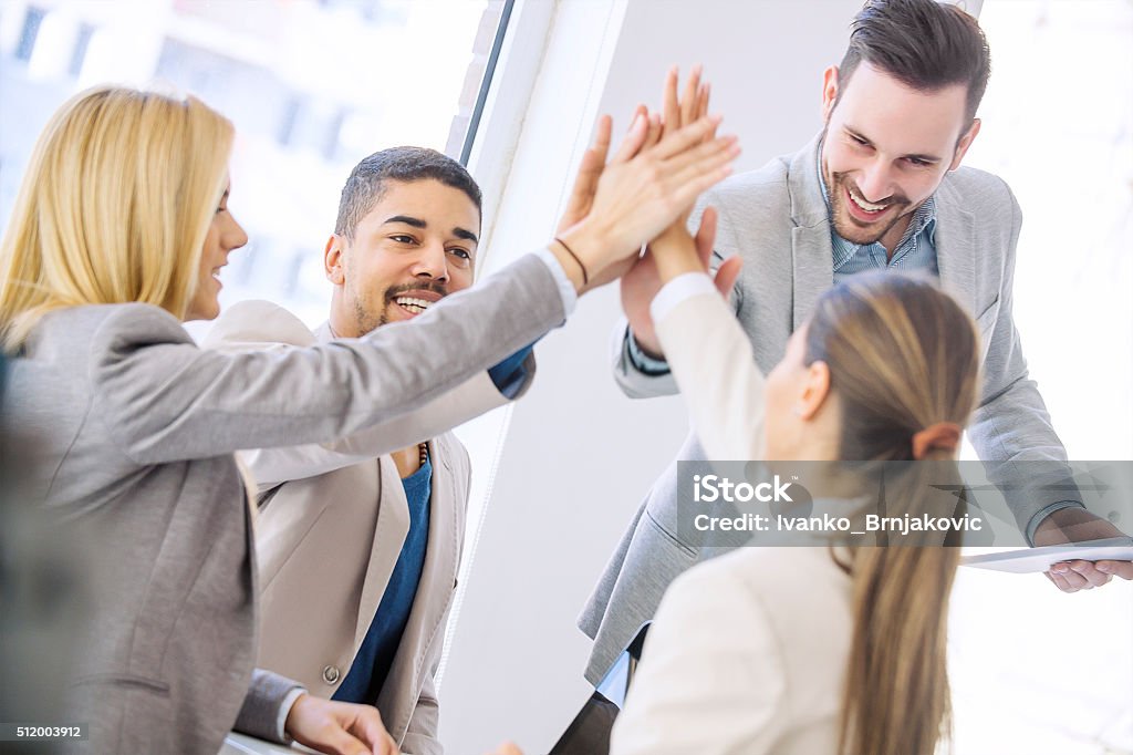Young business people joining hands together for success Shot of a group of colleagues high-fiving each other during an informal meeting.Young business people joining hands together for success. Adult Stock Photo