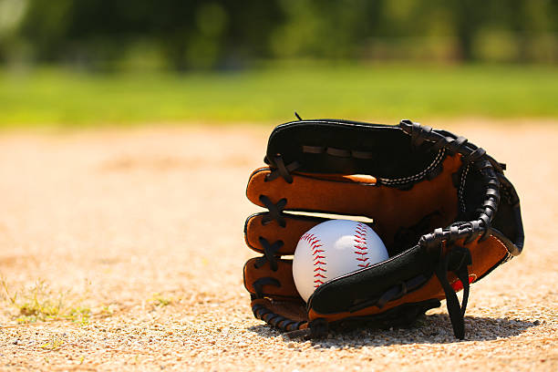 Baseball in Glove on Field Baseball in Glove on Field. Sport high school baseball stock pictures, royalty-free photos & images