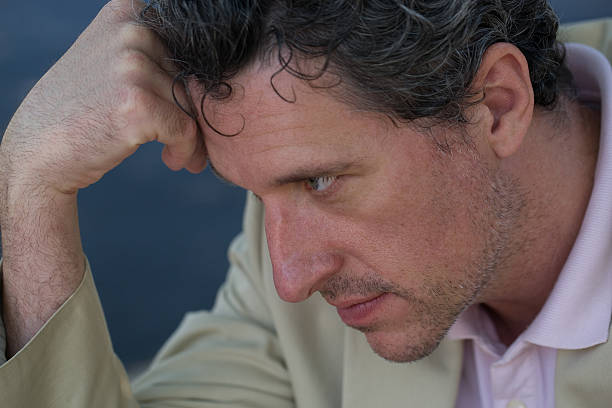 Portrait of a professional mature man assuming the Thinker pose