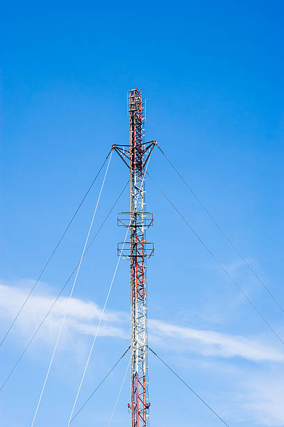 istock Tall red and white antenna on blue sky 512029570