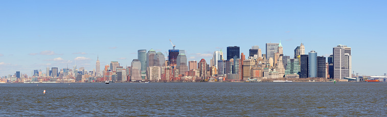 New York City Manhattan downtown skyline panorama view with Empire State Building and skyscrapers with blue clear sky over river