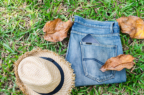 istock jeans and straw hat on green glass background 512030618