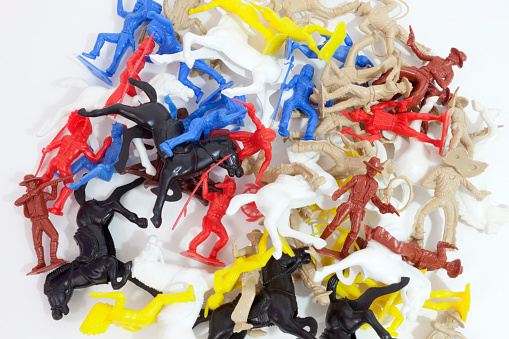 Pile of colorful plastic toy horse, cowboys, and indians. Horizontal.