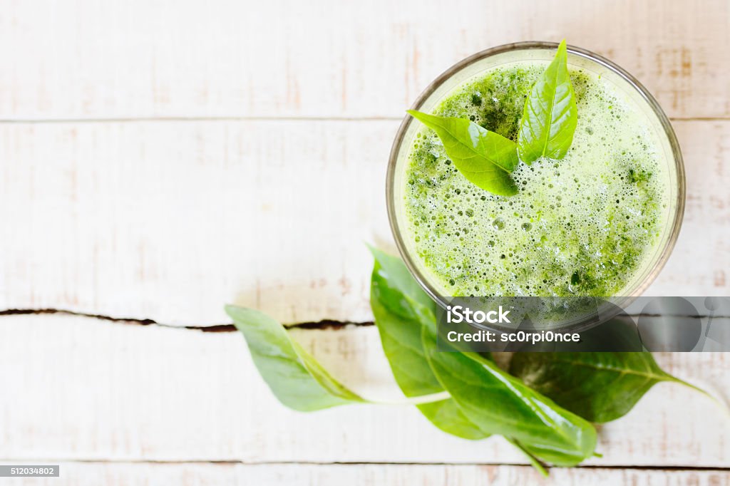 green herbal detox drink made of spinach on white wood Filtered photo of green herbal detox drink made of spinach on white wood. Healthy lifestyle, diet background. Text space Detox Stock Photo