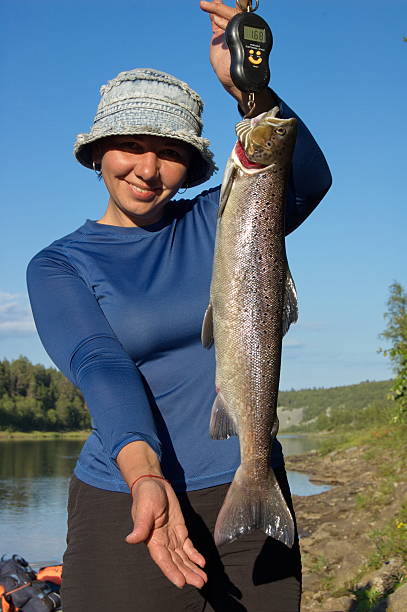 istock Woman weighs a beautiful salmon. 512035674