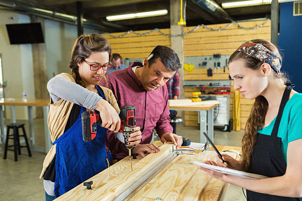 istock Supervisor watches employee drill hole in board 512039686