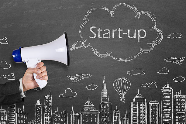 istock Hand holding megaphone with Start-up on cityscape background 512042432