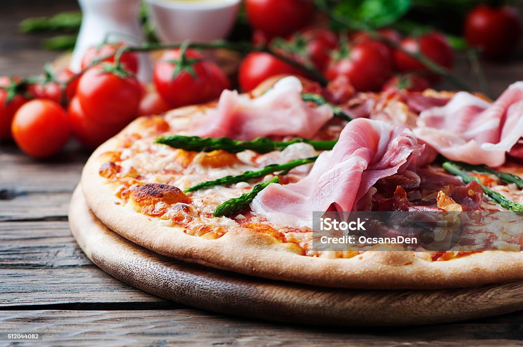 Italian pizza with ham and asparagus Italian pizza with ham and asparagus, selective focus Asparagus Stock Photo