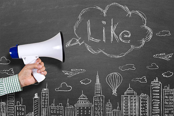 istock Hand holding megaphone with Like on cityscape background 512045090