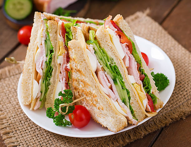 istock Club sandwich with cheese, cucumber, tomato, ham and eggs. 512045878