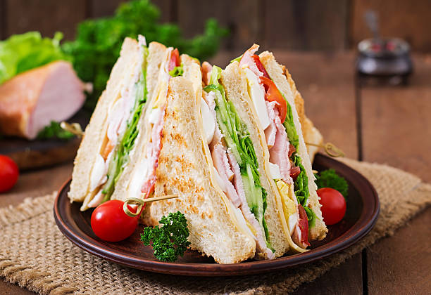 istock Club sandwich with cheese, cucumber, tomato, ham and eggs. 512045976