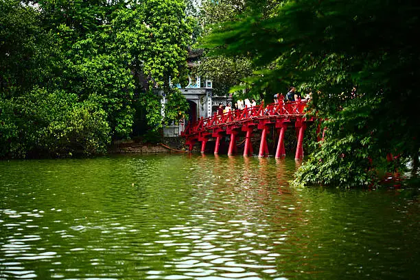 The very scenic red wooden bridge or Huc Bridge (Hoach The Huc) over Hoan Kiem lake in the center of Hanoi., Vietnam.