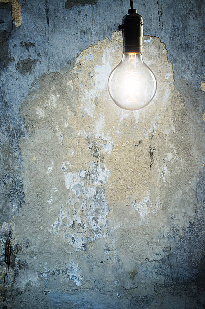 istock Vintage incandescent bulb on wall background 512046528