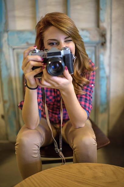istock Young woman taking a photo with retro digital camera. 512046584