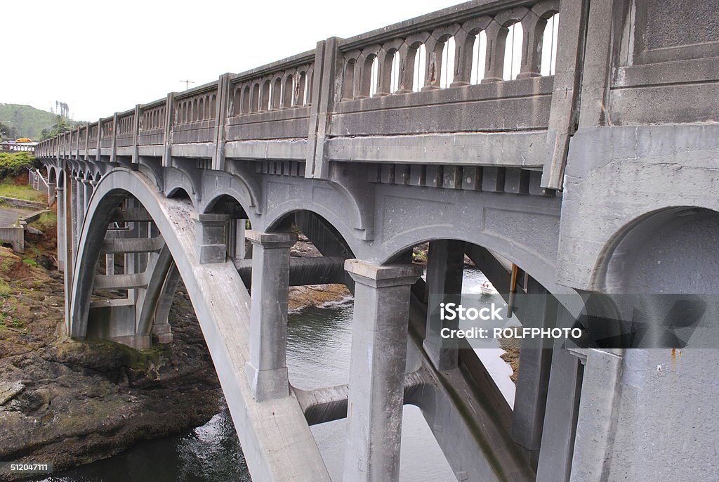 Bridge Across the Water A bridge looms large stretching over a touch of the sea. Arch - Architectural Feature Stock Photo