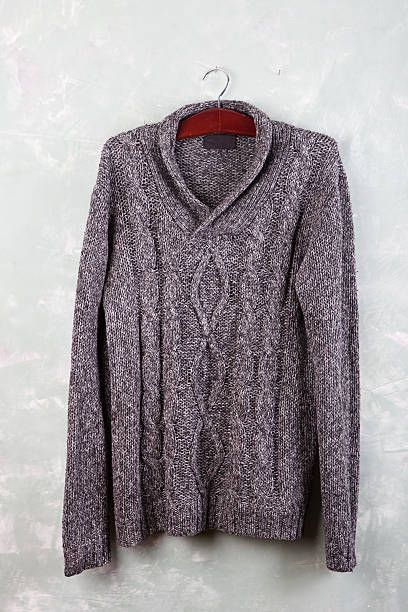 istock Knitted sweater hanging on a hanger on the wall 512047224