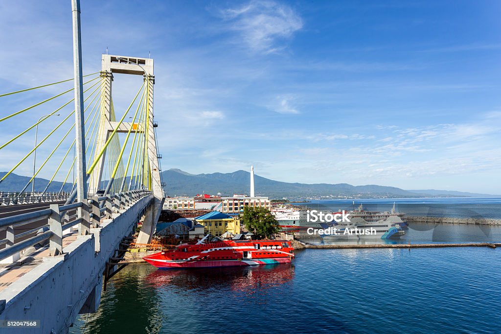 harbor in Manado City, Indonesia view of indian ocean harbor in Kota Manado City, Indonesia with blue sky and bridge in background Asia Stock Photo