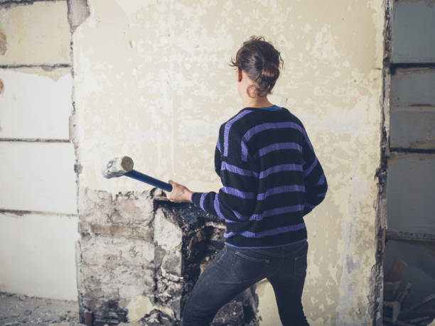 Woman opening up fireplace with sledge hammer