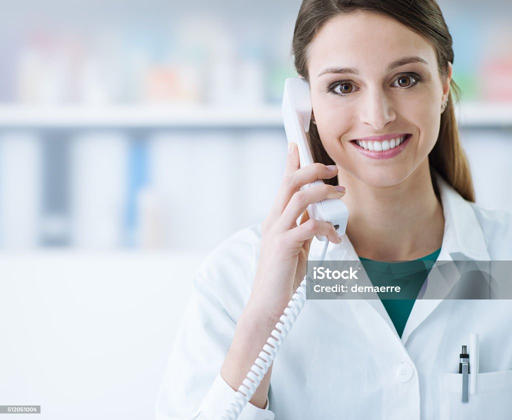 Sonriendo médico de llamada de teléfono - Foto de stock de Usar el teléfono libre de derechos