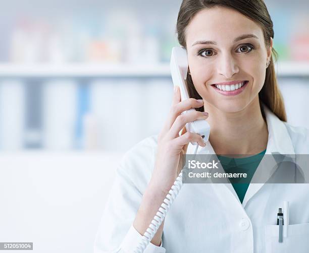 Sonriendo Médico De Llamada De Teléfono Foto de stock y más banco de imágenes de Usar el teléfono - Usar el teléfono, Doctor, Recepcionista