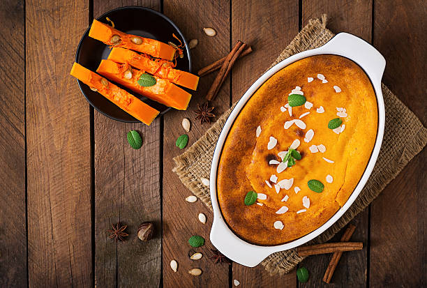 Cottage cheese and pumpkin pudding with cinnamon and nutmeg on wooden background. Top view