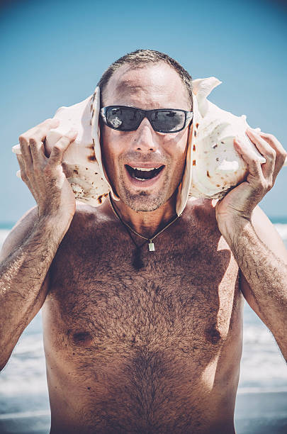 istock Man listening to Sea Shells, mouth open 512053132