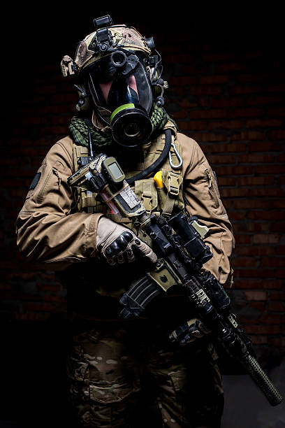 istock Soldier with rifle and respirator on dark background 512055174