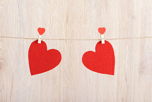 Two red hearts hung on the rope Two red hearts hung on the rope a wooden background pair stock pictures, royalty-free photos & images