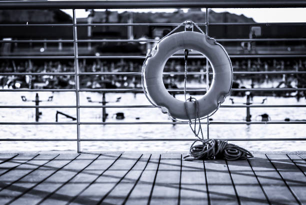 Life Buoy and rope handing on the railings just off a large public pond.