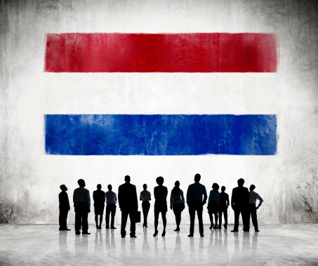 Silhouettes of Business People Looking at the Flag of Netherlands