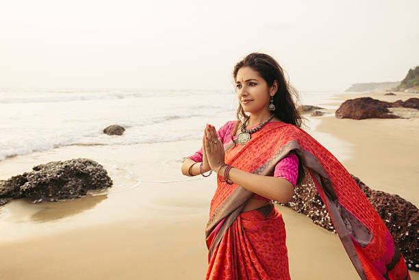 Indian woman praying on the nature Indian woman in traditional saree clothes praying on the nature with sunset on background bharatanatyam dancing stock pictures, royalty-free photos & images