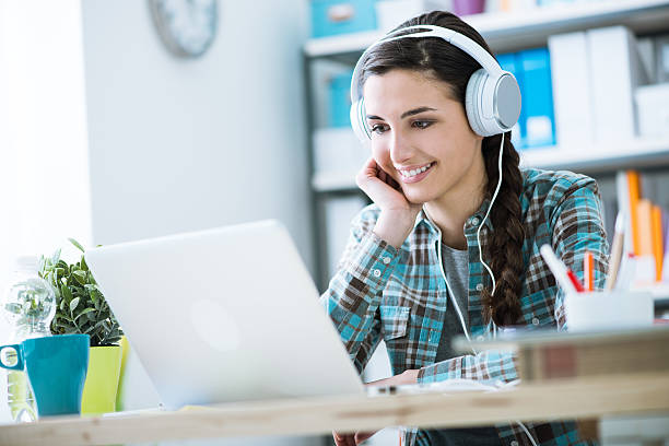 chica con auriculares usando computadora portátil - happy kid audio fotografías e imágenes de stock