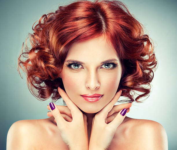 Pretty red-haired girl with curls and fashionable make-up. stock photo