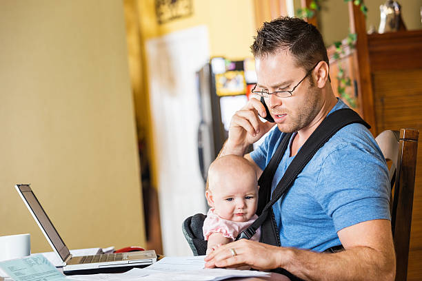 istock Father caring for baby daughter while working in home office 512059341