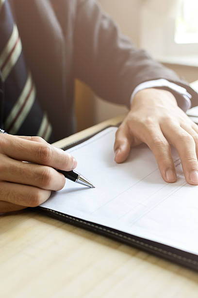 Human Hand Signing on Formal Paper at the workplace