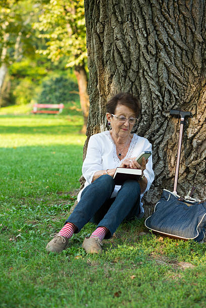 istock Mature woman talking with mobile in the park 512081955