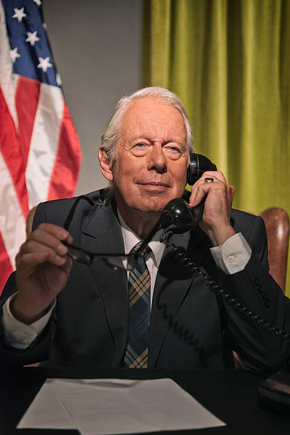 istock Big boss president holding glasses calling behind desk. 512082227